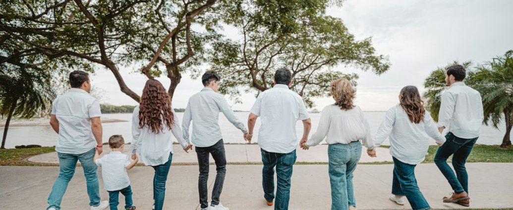 Family holding hands walking by the water